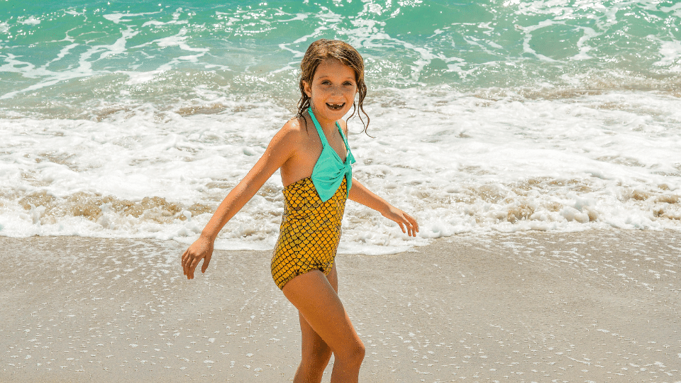 fillette au bord de l'ocean en maillot motif ecaille de sirene